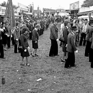 Volks- und Schützenfest: Fest- und Schützenplatz, Jersbeker Straße: Festumzug beim Einmarsch: Schützenvereine mit Fahnen: Zuschauer: beiderseits Jahrmarktstände, im Hintergrund Karussell, 2. August 1981