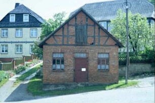 kleines Backsteingebäude (Werkstatt?), dahinter Bauernhäuser