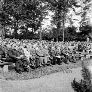 Tag der Deutschen Einheit: Feierstunde: Naturbühne: Bürgerpark: Blick auf Teilnehmer auf Sitzreihen, darunter Kreispräsident Friedrich Hardt, Bürgerworthalter Willy Rosch, Direktor der Theodor-Mommsen-Schule Richard Staberock: hinten Bäume