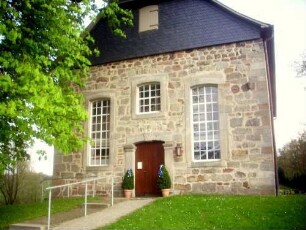 Langhaus von Süden über Giebelseite mit Spolien (Steinkopf und Relief - Spolien der Vorgängerkirche) im Südwesten in Übersicht