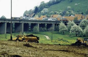 Erdarbeiten Schüttung des großen Dammes. Im Hintergrund alter Aichelbergviadukt im Betrieb.