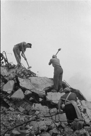 Enttrümmerung im Stadtkern : Dresden. Zwei Frauen und ein Mann auf einem Trümmerberg