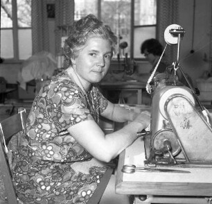 Roßwein, Bahndammstraße. VEB Maßmieder- und Wäschefabrik (vormals Karl Spranger Maßkorsettfabrik). Vorgänge in der Produktion. Näherei. Portrait einer Näherin an der Nähmaschine
