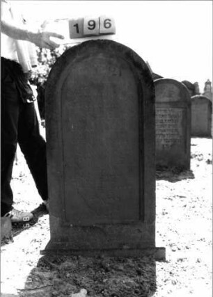 Grabstein 196 (Index: 99797641) Material: Sandstein, rot Zustand: leicht verwittert Maße HxBxT: 109x54x13 cm Beschreibung: Stele, Rundbogenabschluß, Sockel: Grabstein 196