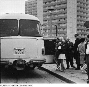 Bushaltestelle vor Appartementhochhäusern (Punkthochhäuser). Zusteigende und wartende Fahrgäste