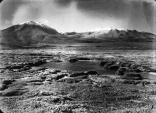 Das Becken des Cerro Chinchillani : Blick über das Becken des Cerro Chinchillani mit dem Vulkan Isluga im Hintergrund.