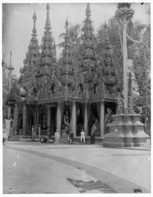 Rangun, Birma. Touristen vor Pagode mit Buddhastatuen