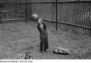 Kleiner Junge, mit einem Ball spielend