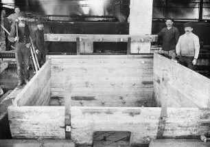 Freiberg-Zug, An der Zugspitze 42. Lederfabrik Zug. Werkteil Zugspitze. Arbeiter in einer Halle (Teilansicht) beim Bau eines großen Holzkastens (für Transport des gegerbten Leders?)