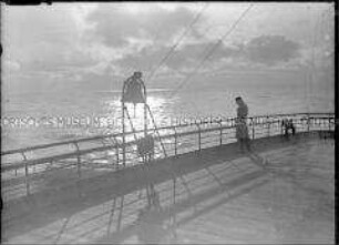 Passagier im Abendlicht an Deck des Hochseepassagierdampfers "Bremen"