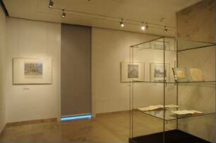 Exponate an der West-Wand (Konzertsaal, Theaterbauten) und Ausstellungsvitrinen mit Musikalien