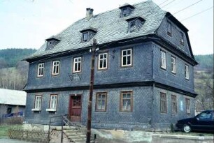 großes Haus mit Krüppelwalmdach, komplett verschiefert, Treppenaufgang zur Haustür