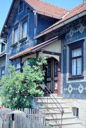 Haus mit Treppenaufgang, Vorbau, reich verzierter Schieferfassade
