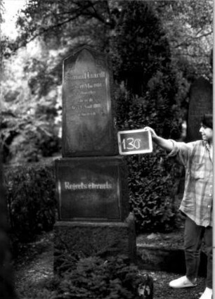 Grabstein 130 (Index: 100109814) Material: Granit Zustand: gut Maße HxBxT: 186x50x26 cm Beschreibung: konische Stele, Doppelsockel, giebelartiger Abschluß Symbolik: Voluten Steinmetz: H. Ostberg: Grabstein 130