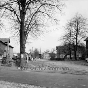 Hauptstraße / Borweg: vorn links Ehrenmal mit Baum und Einfriedung links und rechts Bauernhäuser mit Bäumen: hinten Landahls Gasthof