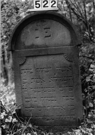 Grabstein 522 (Index: 99802708) Material: Sandstein Zustand: eingesunk/Textverlust Maße HxBxT: 90x50x10 cm Beschreibung: Stele mit verdachtem Rundbogen, profiliertem Rand, Giebelfeld: Grabstein 522