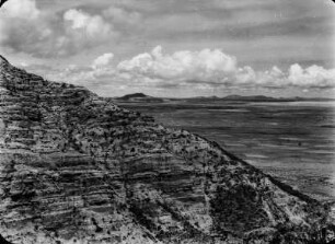 Die Pampa am Lago Poopó : Blick von einem Berg mit horizontal geschichteter roter Sandsteinformation in die Pampa am Lago Poopó mit Cerro Aullagas.
