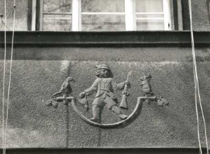 Dresden-Pieschen, Hubertusstraße 53/57. Wohnhauszeile (um 1928). Figürlicher Schmuck. Jäger mit Flinte und Tieren (Nr. 57, 2. Obergeschoss)