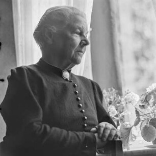Portrait einer älteren Dame, die am Fenster sitzt