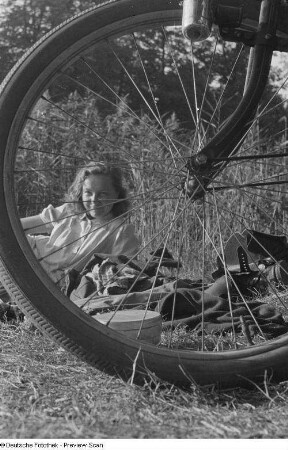 Junge Frau verdeckt durch Fahrradspeichen
