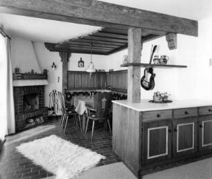 Möbelaufnahmen. Wohnküche. Sitzecke mit Holzdecke und Anrichte. An der Wand eine Gitarre