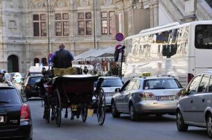 Fiaker-Kutscher im Verkehr : Ein Fiaker fährt seine Kutsche vor der Oper durch den dichten Autoverkehr. Aufgenommen in Wien am 3. September 2009