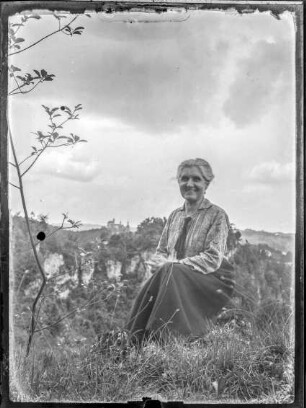 Gößweinstein, Dame im Gras - im Hintergrund Gößweinstein