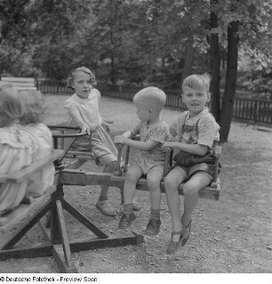 Kinder auf einem Karussell auf einem Spielplatz im im Clara-Zetkin-Park