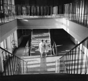 Deutsche Demokratische Republik. Forschungsinstitut. Treppenhaus mit zwei gegenläufigen Treppen und zwei Mitarbeiterinnen