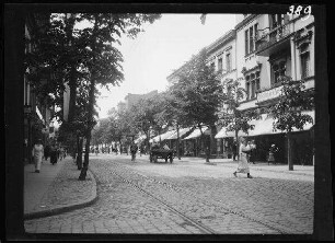 Tilsit (=Sowetsk, Oblast Kaliningrad, Russland): Einkaufsstraße mit Straßenbahngleis und festlich gekleideten Fußgängern ("Tilsit: Hauptstraße")