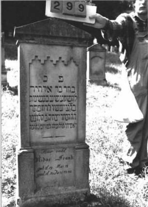 Grabstein 299 (Index: 100106857) Material: Sandstein Zustand: leicht verwittert, Mittelaufsatz fehlt Maße HxBxT: 148x42x13 cm Beschreibung: Stele mit überkragendem Giebel, Mittelaufsatz fehlt, Schriftfeld eingetieft, Sockel: Grabstein 299