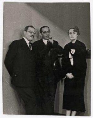 Journalisten und Politiker in den Wandelgängen des Völkerbundpalastes in Genf. von links nach rechts: Némanoff (russischer Journalist), Nikolaos Politis (griechischer Außenminister), Geneviève Tabouis (französische Journalistin)