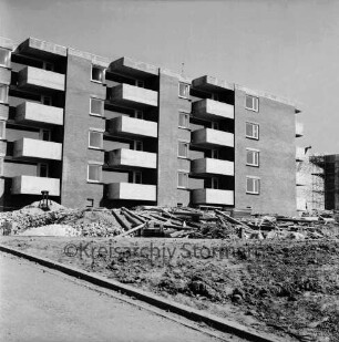 Ehmkenberg: Neubau: Wohnblock vor Fertigstellung: vorn Erdhaufen, Bretterstapel und Bauschutt: hinten rechts eingerüsteter Rohbau