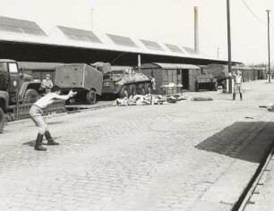 Verladung von Militärtechnik der 1. Gardepanzerarmee im Güterbahnhof Dresden-Neustadt. Soldaten entspannen ein Drahtseil auf der Ladestraße : Dresden-Neustadt. Verladung von Militärtechnik der 1. Gardepanzerarmee im Güterbahnhof Dresden-Neustadt. Soldaten entspannen ein Drahtseil auf der Ladestraße