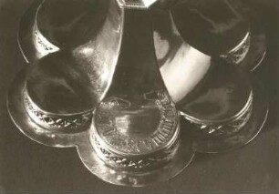 Döbeln, Nikolaikirche. Abendmahlskelch. Silber, vergoldet; Höhe 22 cm, Fußbreite 17 cm. Fußplatte mit fünf Spitzbogen auf Säulen und Kreuzigungsgruppe mit vier Evangelistensymbolen (Höhe je 7 cm). Um 1470. Detail: Fuß mit Symbolen von Johannes und Matthäus