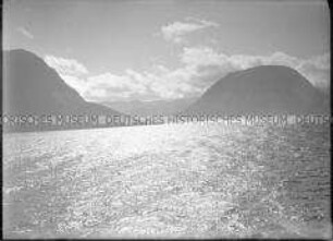 Wolken über dunklen Bergen, Fjord mit leicht gekräuselter Oberfläche, Nordlandreise, Norwegen