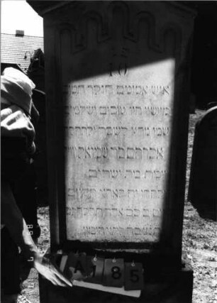 Grabstein 185 (Index: 99797618) Material: Sandstein, weiß Zustand: leicht verwittert Maße HxBxT: 190x70x15 cm Beschreibung: Stele, Giebel rechteckig erhöht, getreppter Sockel Symbolik: Blüten, Rundbogenfries: Grabstein 185A