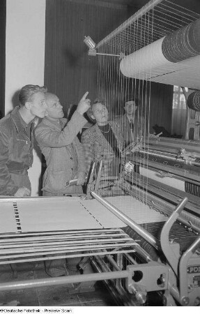 Besucher am Stand der VVB Polygraph während der Vorführung einer papierherstellenden Maschine, Internationale Ausstellung für Buchgewerbe und Graphik (Bugra) 1953