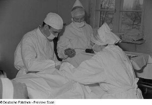 Ein Arzt und zwei Krankenschwestern bei einer Operation im Dr.-Georg-Sacke-Heim