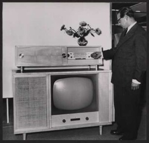 Musikschrank der Max Braun oHG über einem Fernseher