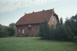Poststraße 10: traufständige Backsteinkate: Straßenfront mit Eingangstür: Giebelseite, Giebelzier Pferdeköpfe