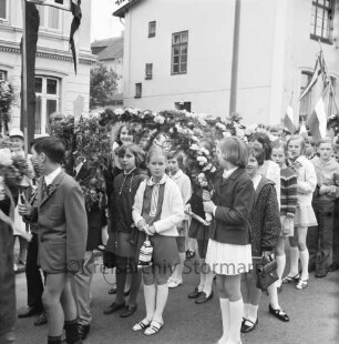 Kindervogelschießen: Umzug: Gruppen der Königin-Luisen-Schule stehn, mit Fähnchen "KLS", Jungen mit Blumenstäben und Fähnchen, Mädchen mit Blumenbögen, 30. Mai 1969