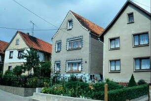 drei giebelständige Häuser mit Vorgärten