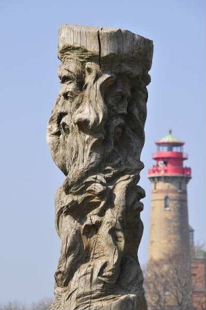 Insel Rügen - Svantevit als Holzskulptur : Holzskulptur des heidnischen Gottes Svantevit, dahinter Leuchtturm. Aufgenommen am 22. April 2011 auf der Insel Rügen am Kap Arkona beim Fischerdorf Vitt