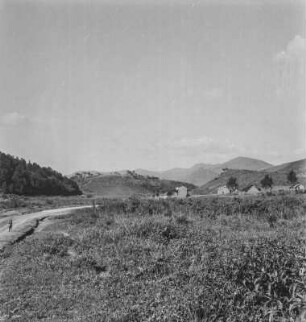 Dorfbild : Blick über ein Feld in Richtung eines Dorfes