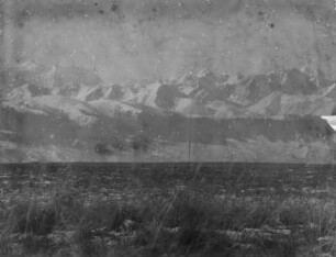 Gebirgszug : Panorama eines schneebedeckten Gebirgszugs vor einer Ebene im Tian Shan Hochgebirge