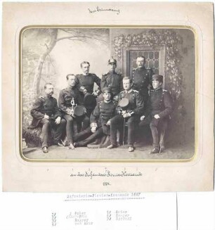 Offiziere (acht Personen) des Infanterie-Pionierkommandos, Ulm, in Uniform, teils stehend oder sitzend in Fotoatelier