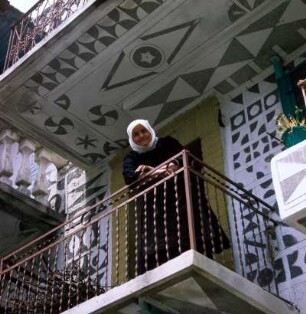 Chios, Pyrgi. Frau auf einem Balkon eines Hauses mit Sgraffito an der Platia