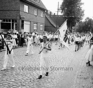Turn- und Sportverein TSV Bargteheide von 1868: 90-jähriges Jubiläum und Kreisturnfest: Umzug: vorne Turner mit Fahne des Deutschen Turner-Bundes: dahinter Turnerinnen und Turner: Zuschauer am Straßenrand, 7. September 1958