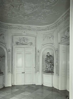Jagdschloß Brühl, Unteres Vestibül : Brühl, Schlosspark Augustusburg. Jagdschloss Falkenlust (1729-1740; F. de Cuvilliés d. Ä.; M. Leveilly). Unteres Vestibül mit Nischenfigur eines Fauns (1733/1735; Entwurf Johann Franz van Helmont) und Stuckdecke von G. P. Castelli und C. P. Morsegno (1732), mittig Kartusche mit kurfürstlichem Wappen unter dem Kurhut
